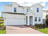 Two-story house with a gray exterior and brick driveway at 27472 Black Kite Ave, Howey In The Hills, FL 34737