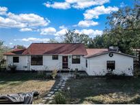 White house with red tile roof, landscaping, and stone pathway at 3250 Mountain Lake Cutoff Rd, Lake Wales, FL 33859