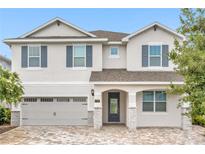 Two-story house with gray siding, gray shutters, and a paved driveway at 7766 Westland Dr, Kissimmee, FL 34747