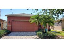 Orange house exterior with a two-car garage and palm trees at 836 Grand Canal Dr, Kissimmee, FL 34759