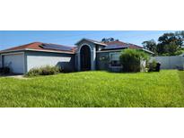 House exterior with solar panels and lawn at 871 Lake Jackson Cir, Apopka, FL 32703
