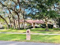Single-story house with a red tile roof, and mature trees in the front yard at 252 Shady Oaks Cir, Lake Mary, FL 32746