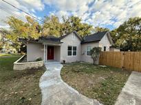 Newly renovated house with a red door, walkway, and wood fence at 1009 Herndon St, Leesburg, FL 34748