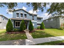 Two-story house with blue exterior and manicured lawn at 14443 Golden Rain Tree Blvd, Orlando, FL 32828