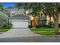 Two-story house with a white garage door and landscaped lawn at 8404 Secret Key Cv, Kissimmee, FL 34747