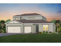 Two-story house with gray siding, two-car garage, and green lawn at 15065 Willow Ridge Dr, Montverde, FL 34756