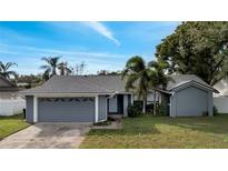 Blue house with a two-car garage and landscaping at 5125 Formby Dr, Orlando, FL 32812