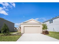 House exterior featuring a two-car garage and well-manicured lawn at 188 Brinsmead Rd, Haines City, FL 33844