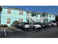 Light teal condo building with ample parking and landscaping at 3128 Sun Lake Ct # A, Kissimmee, FL 34747