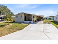 Inviting mobile home with carport and landscaped lawn at 711 Polo Park Blvd, Davenport, FL 33897