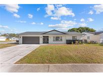 Updated single-story home with a modern garage door and landscaping at 745 Maloney Ln, Orlando, FL 32825