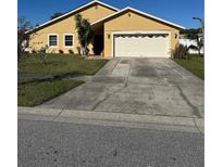One-story house with a two-car garage and well-maintained lawn at 12136 Florida Woods Ln, Orlando, FL 32824