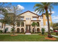 Three-story townhome with stucco exterior, arched entryways, and landscaped grounds at 2108 Lobelia Dr, Lake Mary, FL 32746