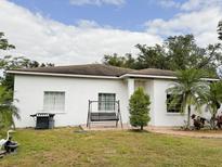 White single-story house with a swing and nicely landscaped lawn at 2109 Morning Dr, Orlando, FL 32809