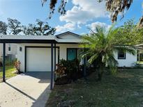 White house with teal door, carport, and landscaped yard at 4171 Radford Rd, Bartow, FL 33830