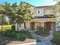 Two story townhome with a Spanish tile roof, landscaping, and a brick walkway at 4787 Terrasonesta Dr, Davenport, FL 33837