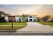 Modern two-story house with a large driveway and landscaped lawn at 15614 Espalier Way, Winter Garden, FL 34787