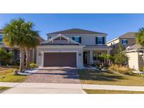 Two-story house with a brown garage door and landscaped yard at 2695 Plume Rd, Clermont, FL 34711