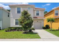 Two-story house with gray siding, landscaping, and a driveway at 2946 Banana Palm Dr, Kissimmee, FL 34747