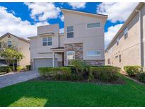 Two-story modern home with stone accents and a landscaped lawn at 8956 Hilton Ridge Ave, Kissimmee, FL 34747