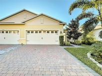 Two-car garage, paver driveway, and attractive landscaping at 3813 Myrtle Oak Ct, Clermont, FL 34714