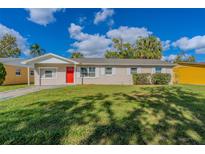 Updated ranch home with a red door and well-manicured lawn at 5235 Botany Ct, Orlando, FL 32811