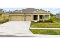 Two-car garage and front yard with landscaping at 729 Hitch Loop, St Cloud, FL 34772