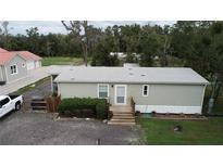 Single-wide mobile home with grey siding, steps, and landscaping at 1111 Sunflower Trl, Orlando, FL 32833