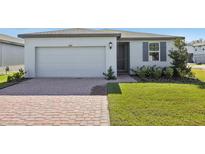 One-story house with gray shutters, a paved driveway, and a well-manicured lawn at 4702 Jasmine Cir, Leesburg, FL 34748