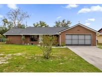 Brick ranch home with attached garage and spacious yard at 857 S Atmore Cir, Deltona, FL 32725