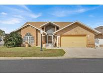 Brick house with a two-car garage and well-maintained lawn at 543 Clubhill Dr, Haines City, FL 33844