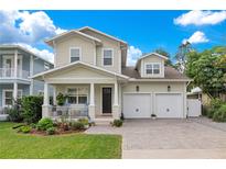 Two-story house with a two car garage, front porch, and landscaped yard at 1018 Wilks Ave, Belle Isle, FL 32809