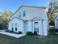 Two-story house with light beige exterior, two-car garage, and landscaping at 1241 Melontree Ct # 6, Gotha, FL 34734