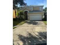 Two-story house with a large driveway and a three-car garage at 4704 Delray Beach Ct, Kissimmee, FL 34746
