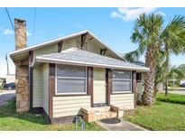Charming bungalow exterior with a stone chimney and landscaping at 5305 S Ridgewood Ave, Port Orange, FL 32127