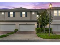 Two-story townhome with two-car garage and landscaped front yard at 15211 Willow Arbor Cir, Orlando, FL 32824