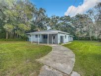 Ranch home with carport, curved driveway & grassy yard at 143 N Woodward Ave, Deland, FL 32720