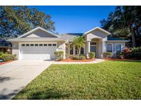 Tan one-story house with a two-car garage and manicured lawn at 16006 Arrowhead Trl, Clermont, FL 34711