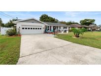 White single story home with attached garage and landscaped lawn at 47 Community Dr, Debary, FL 32713