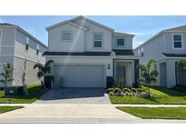 Two-story house with gray siding, gray garage door, and landscaped lawn at 3763 Lana Ave, Davenport, FL 33897