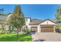 Two-story house with a two-car garage and landscaped lawn at 8441 Chilton Dr, Orlando, FL 32836