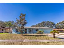 Ranch style home with light blue exterior, mature landscaping, and a two-car garage at 1716 Sprucewood Ln, Orlando, FL 32818