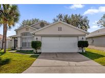 Front view of a single-story house with a two-car garage and landscaping at 2238 Wyndam Way, Kissimmee, FL 34743