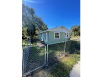 Green house exterior with a chain link fence and walkway at 922 Nw 7Th St, Ocala, FL 34475