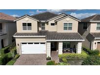 Two-story house with tan exterior, white garage door, and landscaping at 9859 Winnington St, Orlando, FL 32832