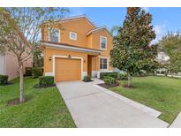 Two-story house with orange exterior, attached garage, and landscaped lawn at 2948 Banana Palm Dr, Kissimmee, FL 34747