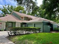 Green two-story house with a double garage and well-manicured lawn at 4532 Oak Arbor Cir, Orlando, FL 32808