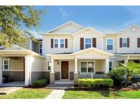 Two-story tan house with brown shutters, porch, and landscaped yard at 5892 Soter Ln, Windermere, FL 34786