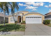 Cute one-story house with a two-car garage and well-maintained lawn at 8160 Fan Palm Way, Kissimmee, FL 34747