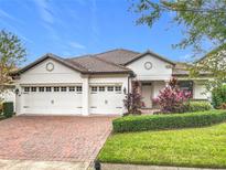 Two-story house with a three-car garage and manicured landscaping at 8914 Dove Valley Way, Davenport, FL 33896